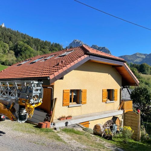 Maison avec charpente et tuiles terre entourée de montagnes
